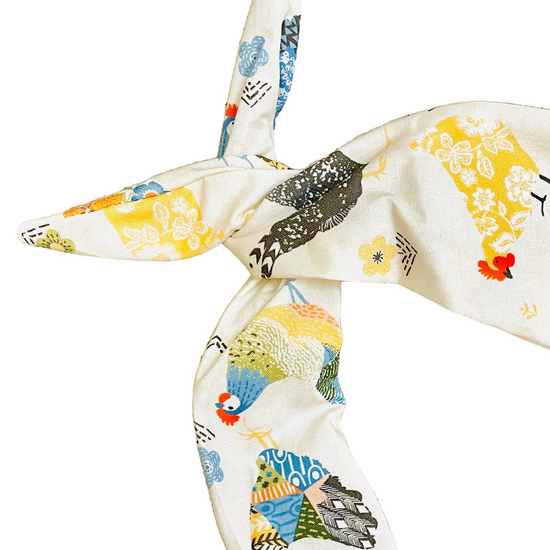Amanda bright designs farmhouse style cream-colored fabric headband with a colorful, whimsical print of chickens and flowers