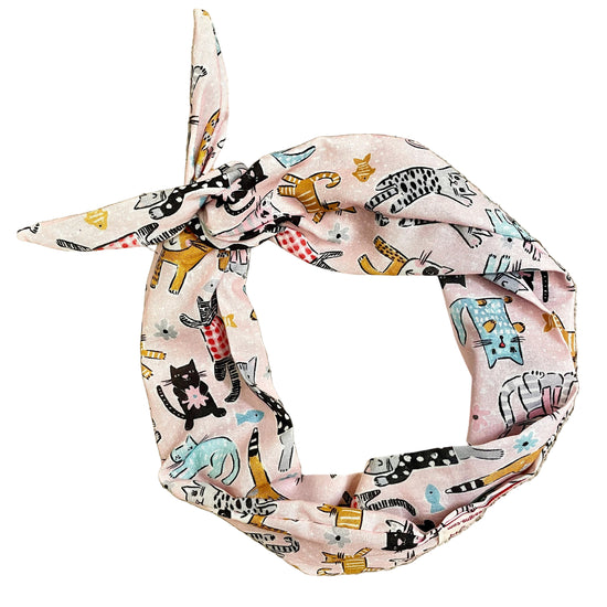 Amanda Bright Designs light pink fabric headband with a tie knot, featuring a playful cartoon cat animal print