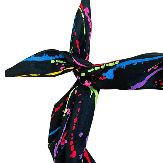 Amanda Bright Designs black headband with neon paint splatter close-up view