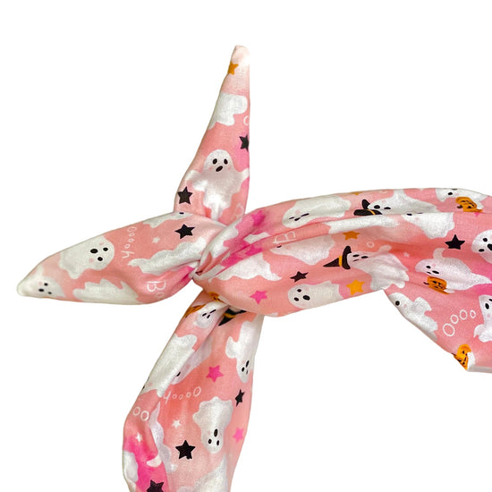 Amanda Bright Designs pink and white head headband with a Halloween print of ghosts, witches, pumpkins, and stars, styled in a knot twist