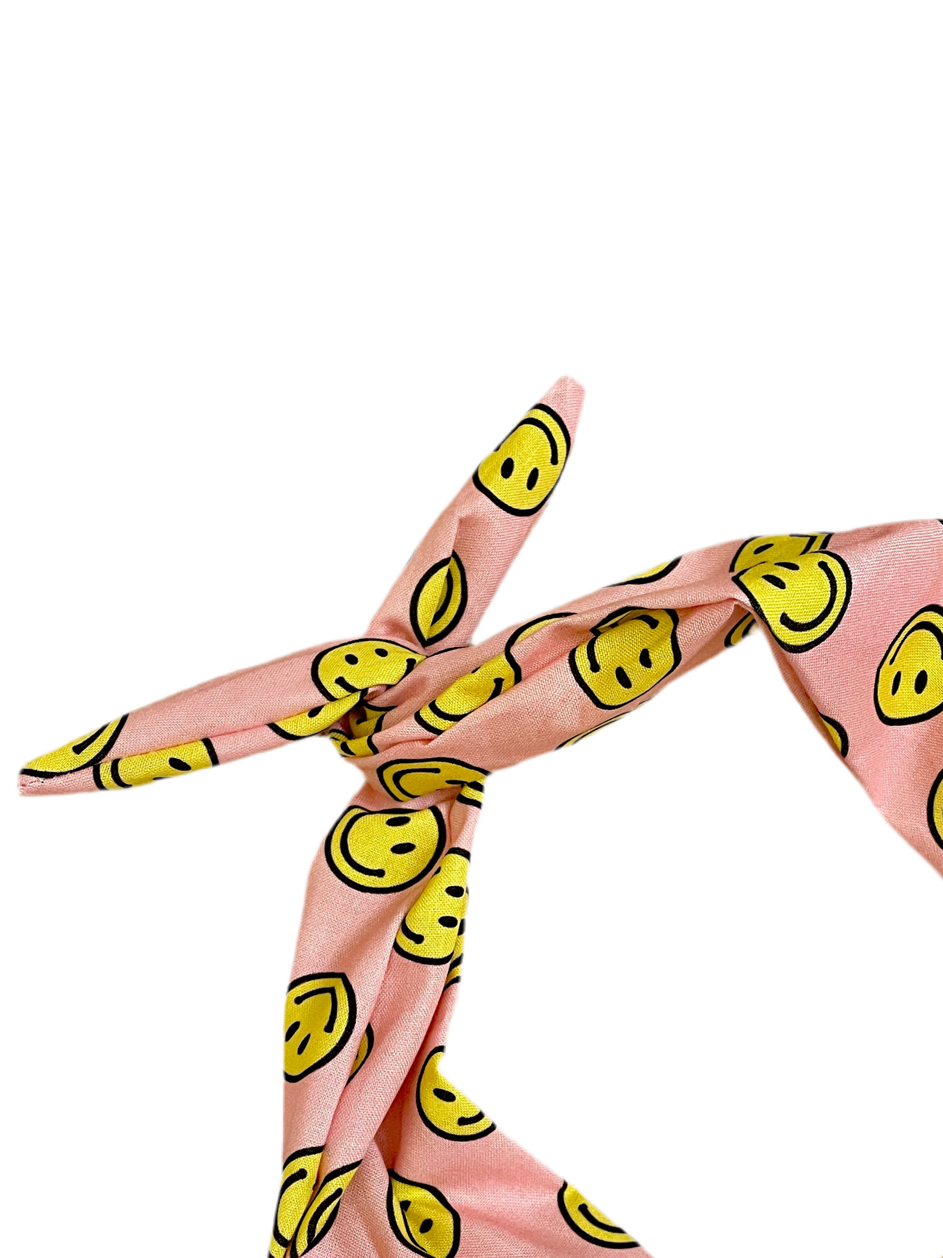 Pink headband with a yellow smiley face pattern, tied in a knot