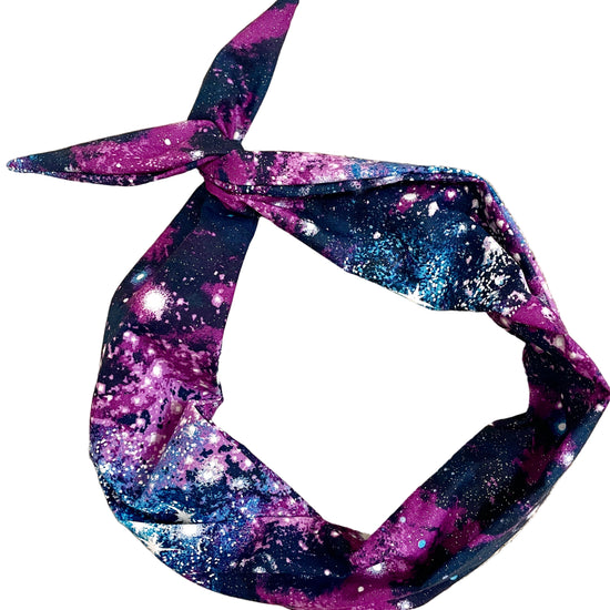 Amanda Bright Designs original tie headband space cosmos glitter headband for women in violet, magenta, midnight blue, and electric blue scattered with shimmering stars and celestial bursts, creating the look of a spectacular night sky