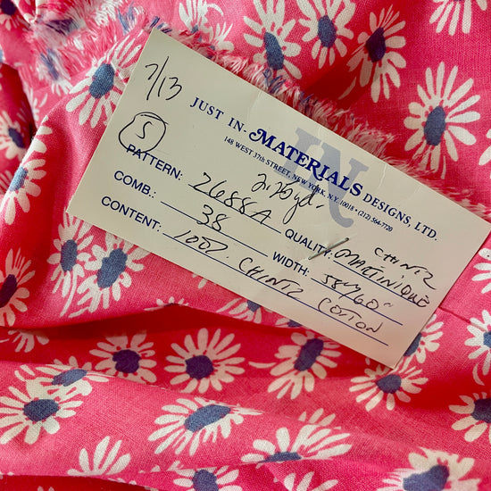 Amanda Bright Designs Close-up of pink floral fabric with a label 