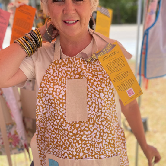 amanda bright designs ginger cotton apron on model golden leopard pattern at pop up