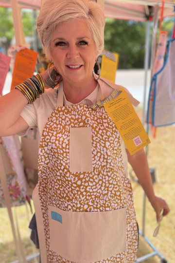 amanda bright designs ginger cotton apron on model golden leopard pattern at pop up