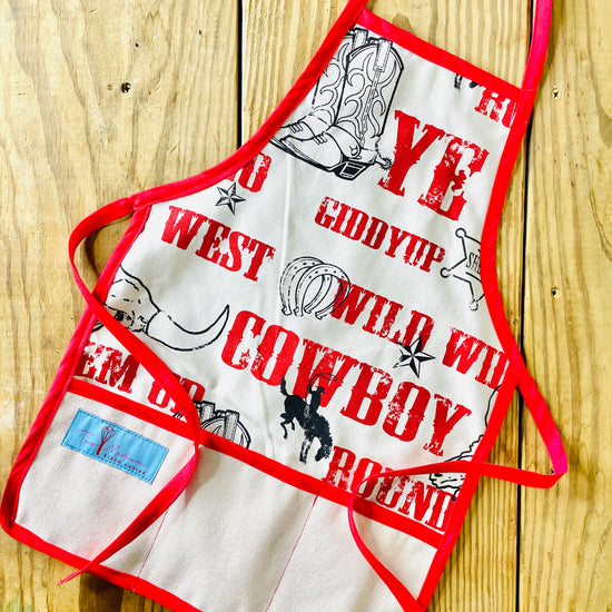 Two Medium Sized Ladies Jane Apron Children's Cowboy Print Giddy Wild West Horse Spurs Boots with Red Apron Strings and Three Pockets
