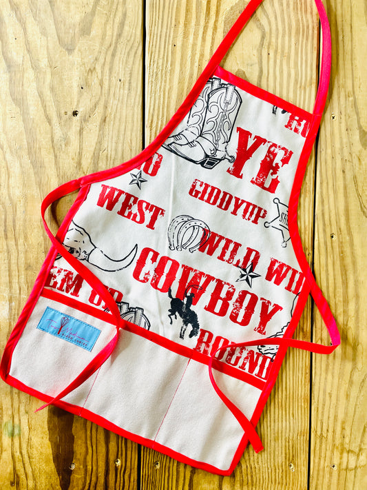 Two Medium Sized Ladies Jane Apron Children's Cowboy Print Giddy Wild West Horse Spurs Boots with Red Apron Strings and Three Pockets