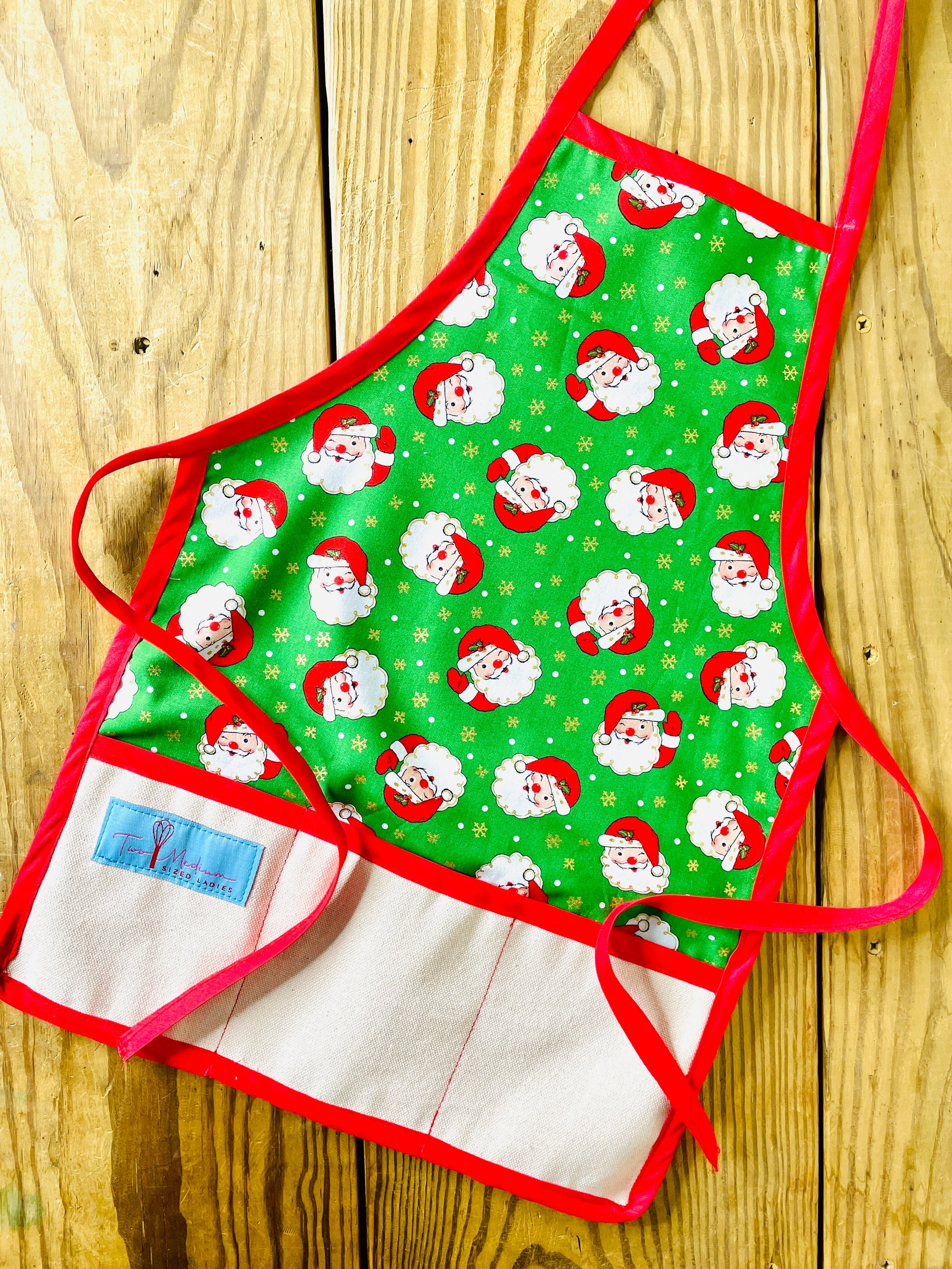 Two Medium Sized Ladies Winking Santas Vintage Style Children's Christmas Aprons green with gold starbursts and red aprons strings