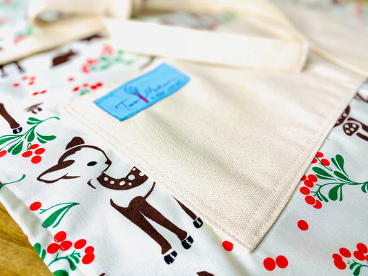 Two Medium Sized Ladies Baby Deer Reindeer Forest Fawn Apron featuring brown spotted fawns green holly red berries and mushrooms on forest floor