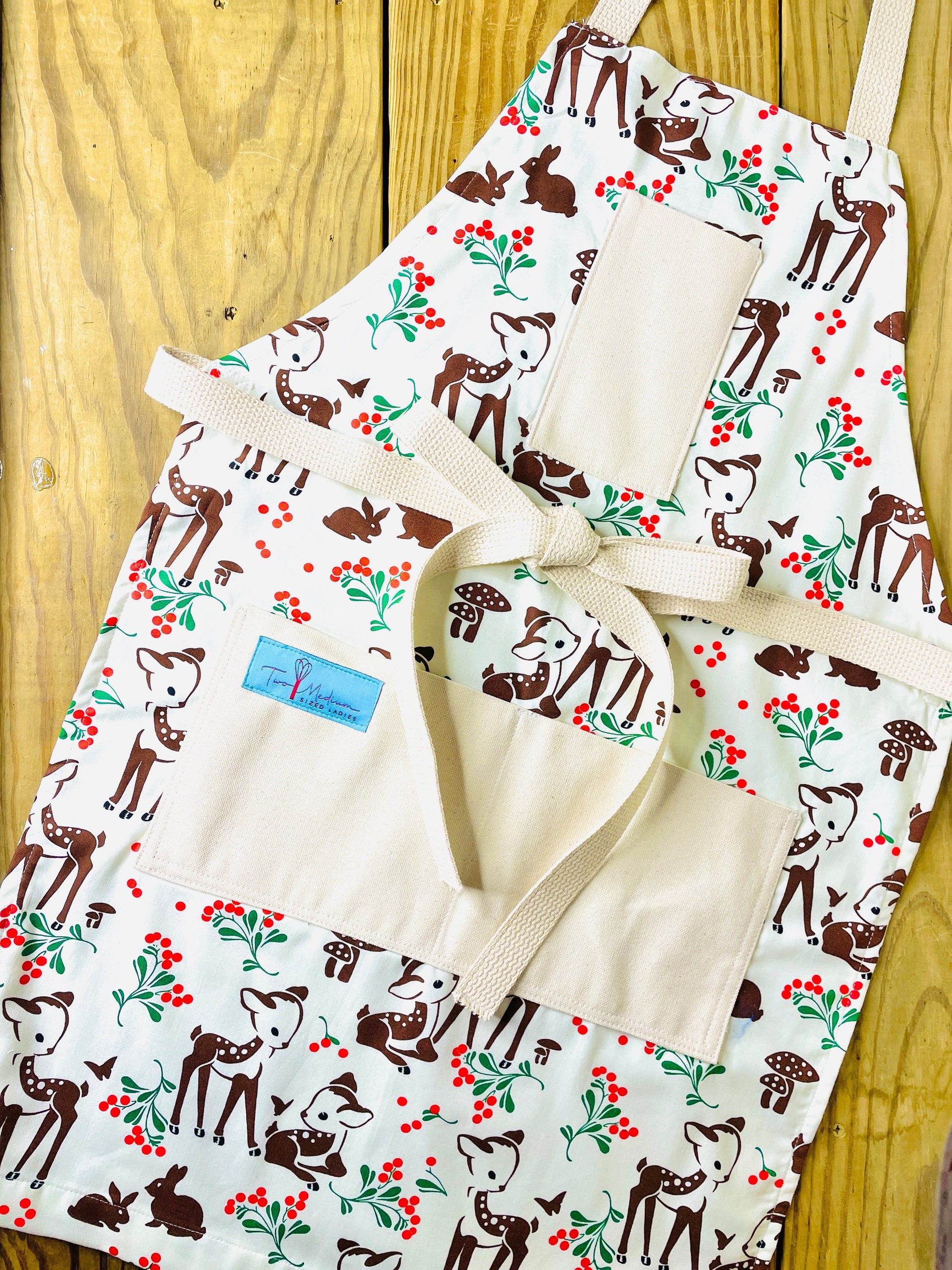 Two Medium Sized Ladies Reindeer Forest Fawn Apron featuring brown spotted fawns green holly red berries mushrooms butterflies