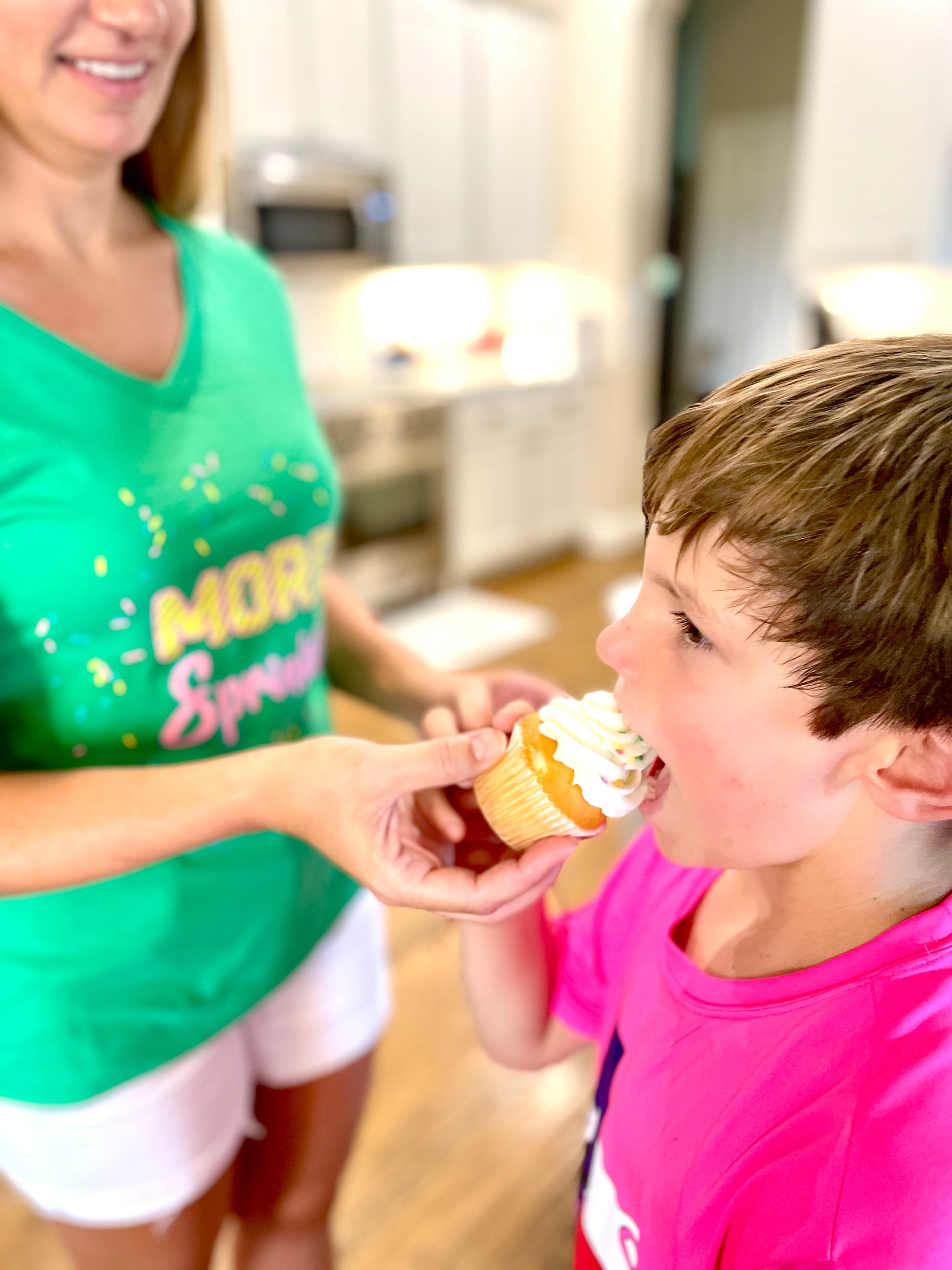 Two Medium Sized Ladies More Sprinkles green v neck cotton t-shirt with bubblegum pink and yellow stripe cake sprinkles mom and child in kitchen eating cupcake with sprinkles