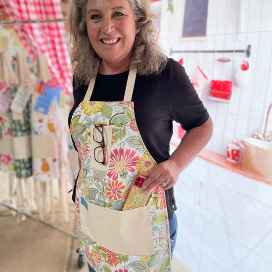 Two Medium Sized Ladies retro groovy 1960s flowers Charlotte peach orange raspberry soft green kitchen baking gardening cooking apron on model