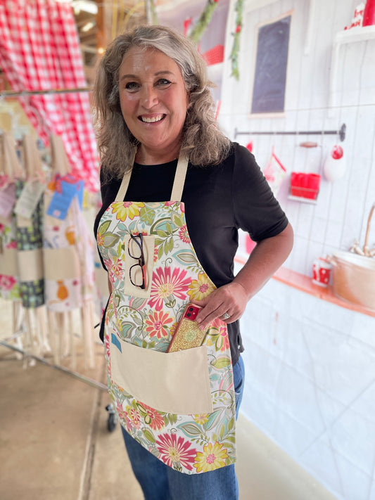 Two Medium Sized Ladies retro groovy 1960s flowers Charlotte peach orange raspberry soft green kitchen baking gardening cooking apron on model