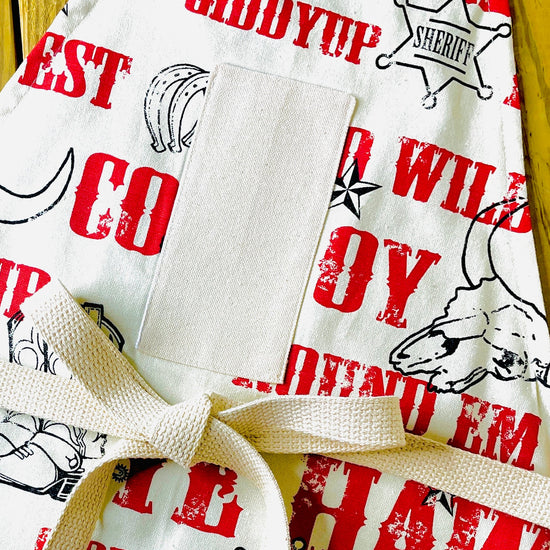 Cowboy Apron Jane Long Mother of Texas boots, steer, sheriff badge, stars, horseshoes, roping cowboy, horse