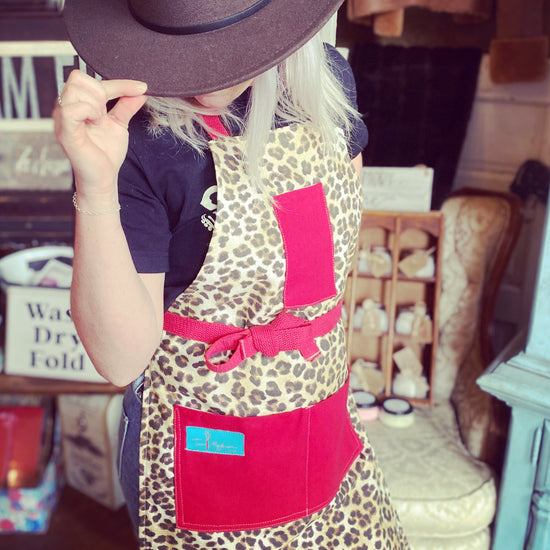 Kat Retro Designer Midcentury Apron Leopard 1950s Glamorous Animal Print Red Strings and Pockets on model