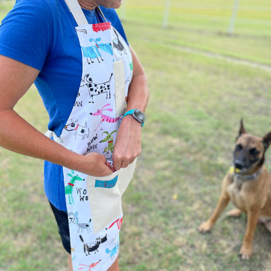 colorful playful dog apron Maribeth on dog trainer putting treats in pocket for pet