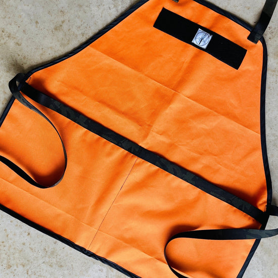 Amanda Bright Designs The Hunter Bright Orange Ottertex Waterproof Canvas Apron with black nylon webbing and strings towel loop