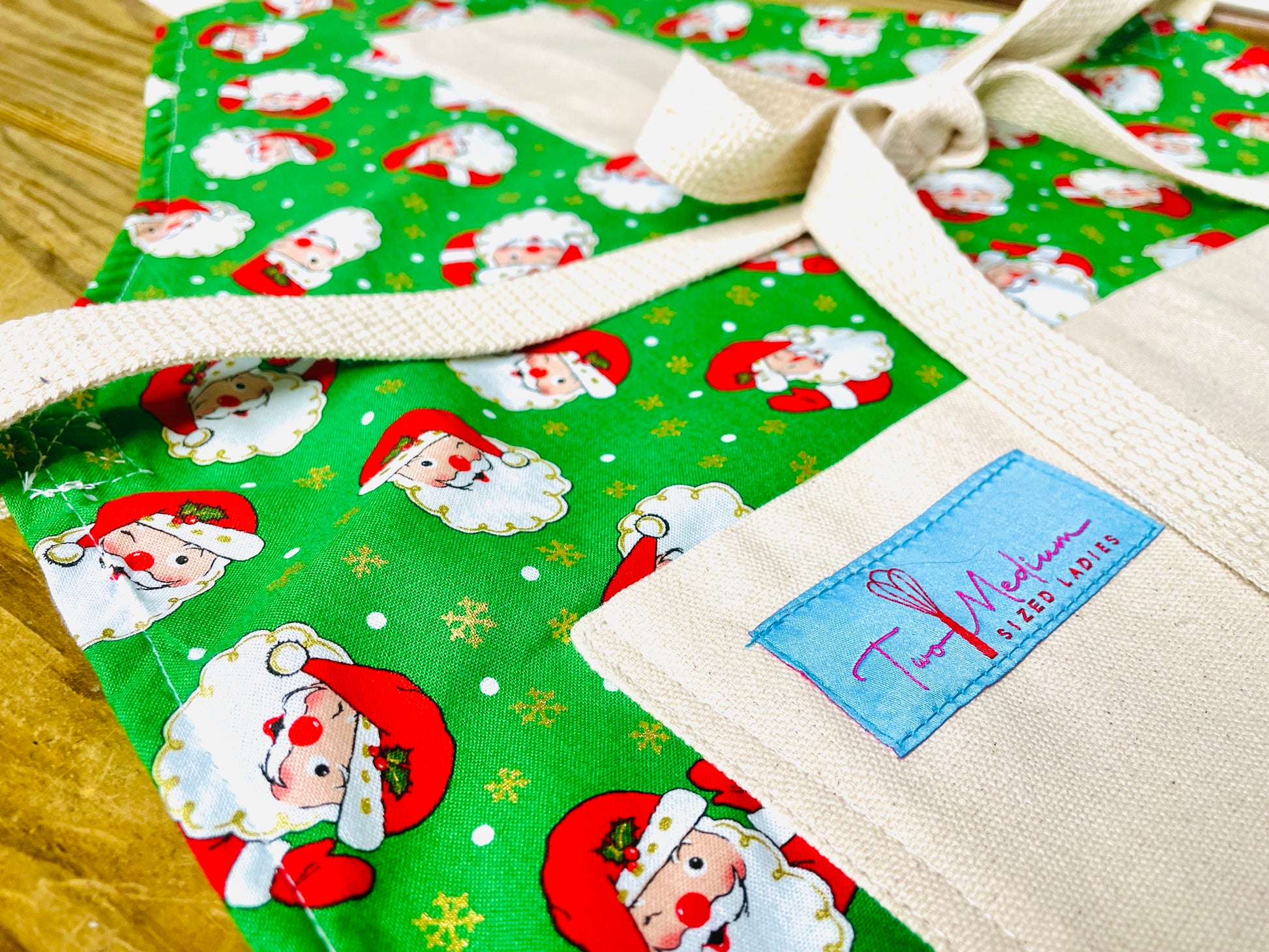 Two Medium Sized Ladies Winking Santa Vintage Style Christmas Apron for baking cooking retro style in the kitchen serving entertaining napco closeup view